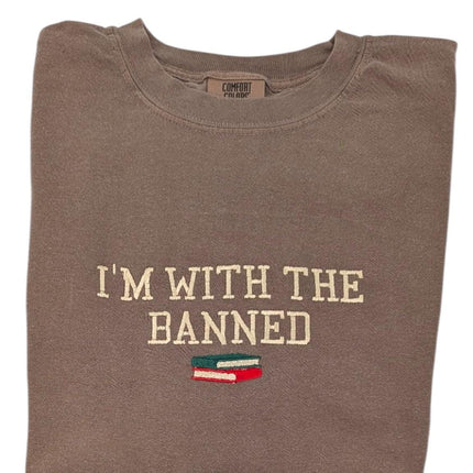 a brown t - shirt that says i'm with the banned