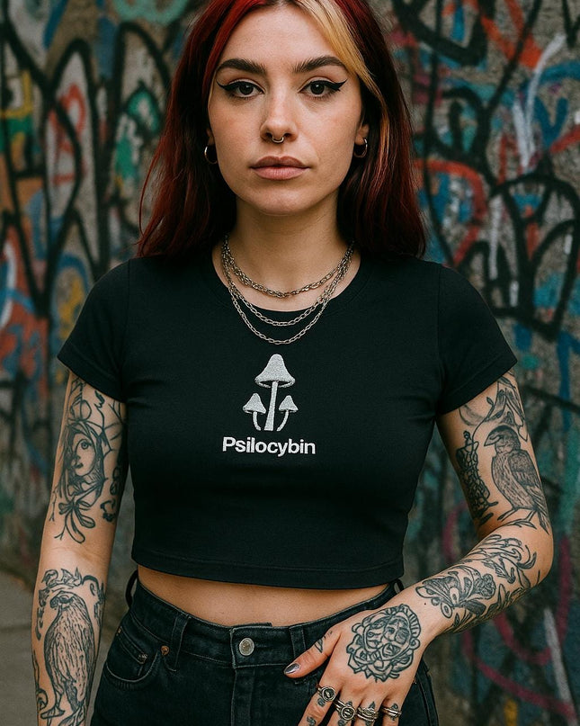 a woman with tattoos standing in front of a wall