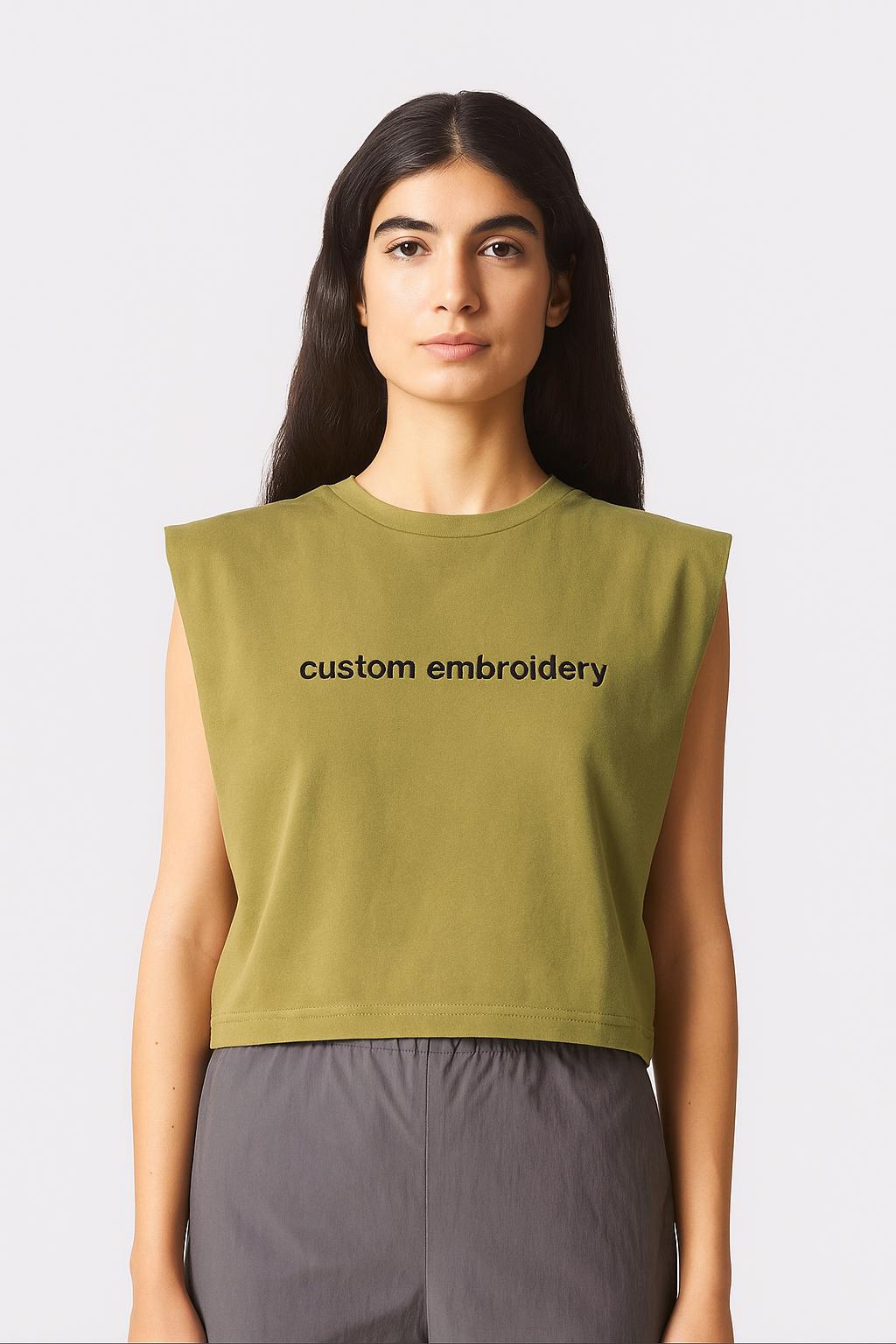 a woman wearing a green shirt with the words custom embroidery on it