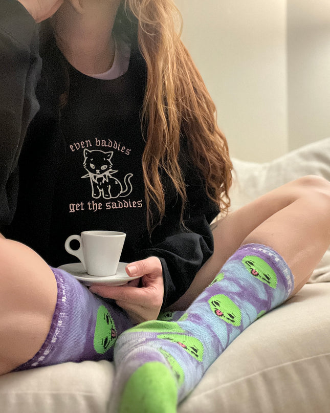 a woman sitting on a couch holding a cup of coffee
