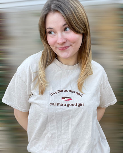 a woman with a white shirt that says buy me books and call me a good