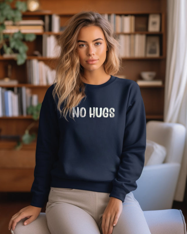 a woman sitting on a chair wearing a sweatshirt that says no hugs