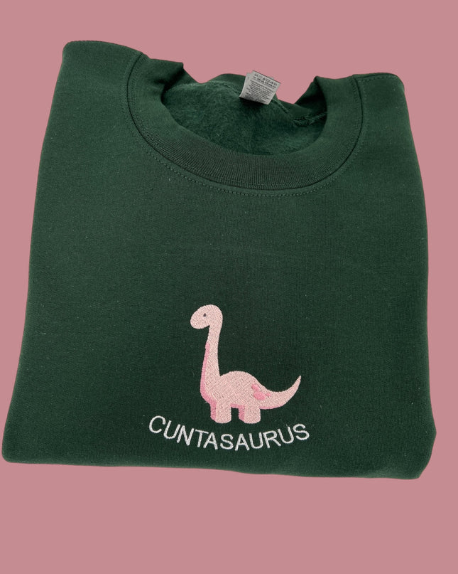 a green t - shirt with a pink dinosaur on it