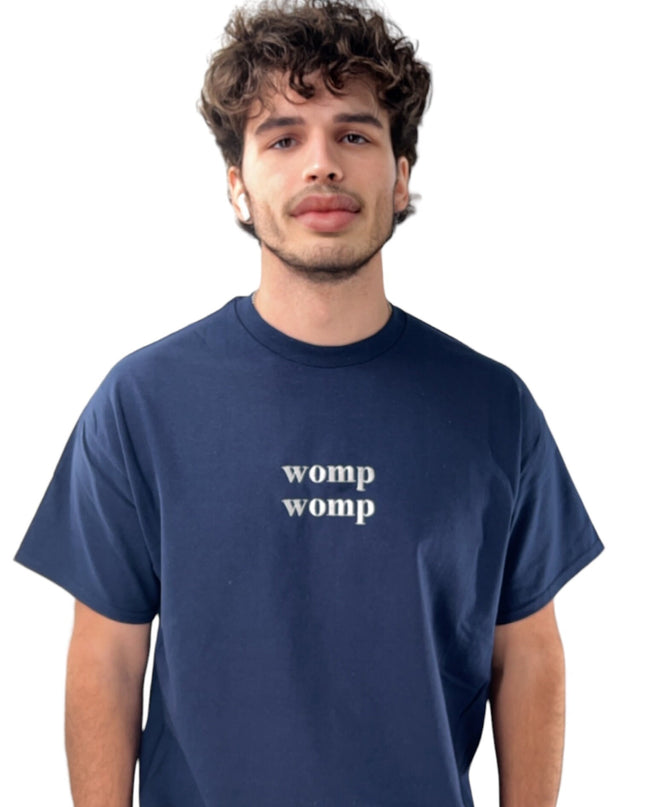 a man wearing a blue t - shirt that says women womp