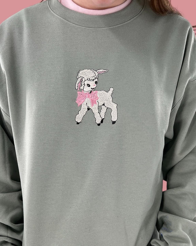 a woman wearing a gray sweatshirt with a pink poodle on it