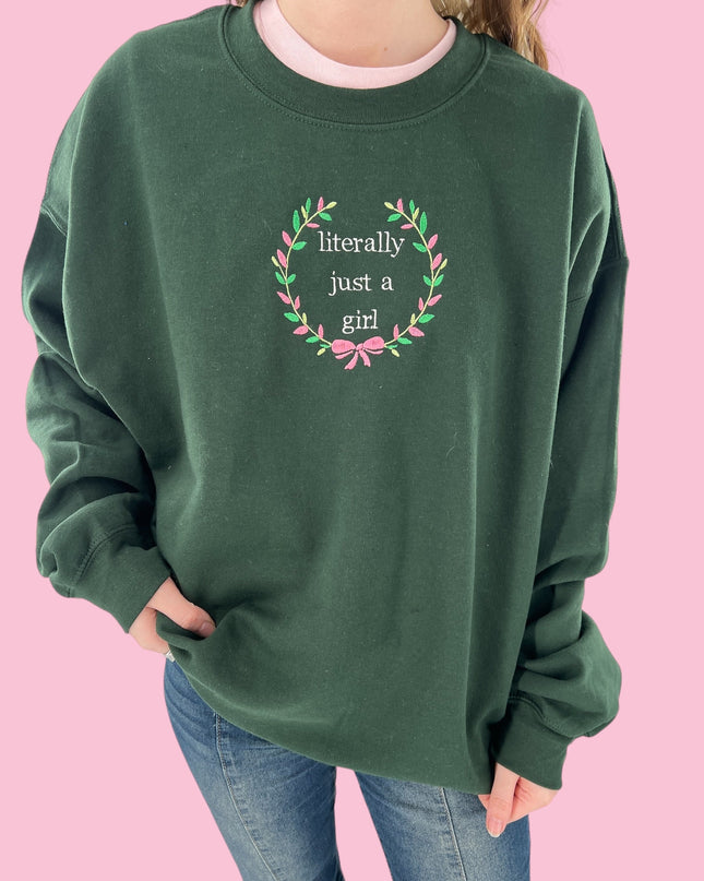 a woman wearing a green sweatshirt with a wreath on it