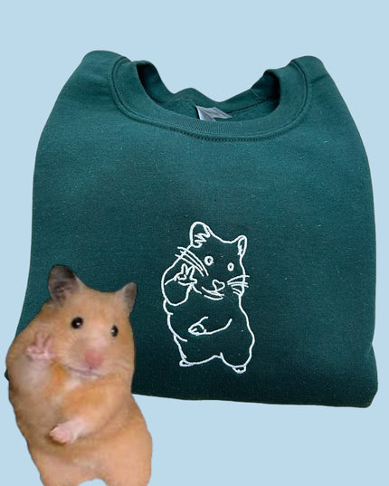 a hamster sitting next to a green bag